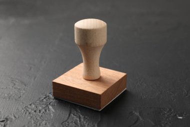 Koyu desenli bir masa üzerinde ahşap bir damga, yakın plan.