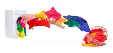 Çamaşır makinesi ve beyaz arka planda uçan çamaşırlar.