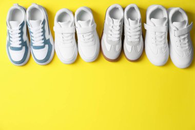 Sarı arka planda şık bir çocuğun spor ayakkabısı, düz bir şekilde yatıyordu. Metin için boşluk