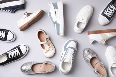 Gri arka planda pek çok şık çocuk ayakkabısı var.