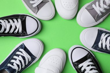 Yeşil arka planda şık bir çocuğun spor ayakkabısının çerçevesi düz. Metin için boşluk