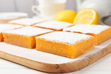 Lezzetli limonlu kekler ve beyaz ahşap masada taze meyveler, yakın plan.