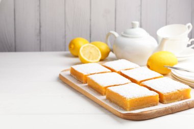 Lezzetli limonlu kekler ve beyaz ahşap masada taze meyveler, yakın plan. Metin için boşluk