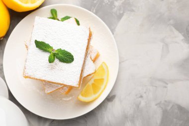 Nane ve taze meyveli lezzetli limonlu kekler gri mermer masa, düz yatak. Metin için boşluk