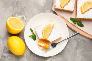 Nane ve taze meyveli lezzetli limonlu kekler gri mermer masada, düz uzanmış.