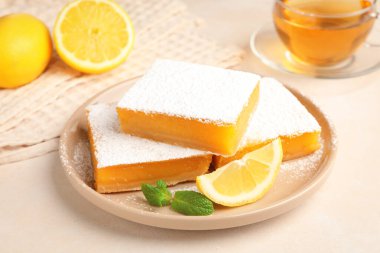 Nane, taze meyve ve bej masadaki çay ile nefis limonlu barlar, yakın plan.