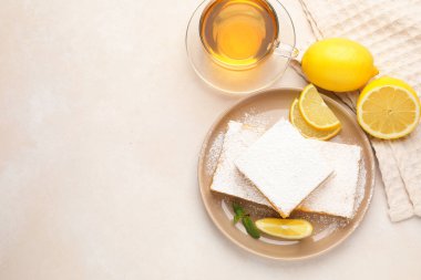 Nane, taze meyve ve bej masadaki çay ile lezzetli limonlu barlar, düz yatak. Metin için boşluk