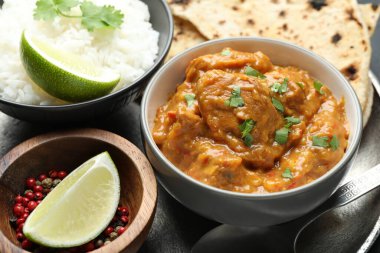 Lezzetli tavuk tikka masala, kişniş, pirinç, limon ve biber tabakta, yakın plan.