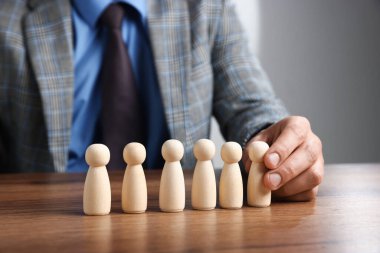 Ahşap masada insan figürlü bir adam, yakın plan.