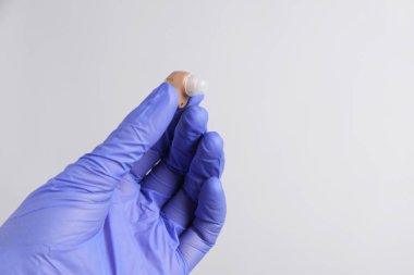 Açık gri arka planda işitme cihazı olan doktor, yakın plan. Metin için boşluk