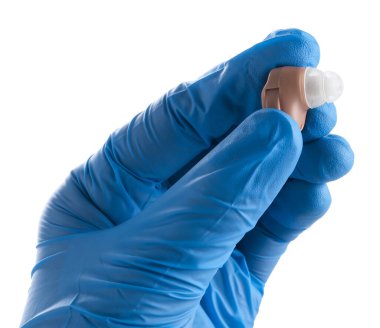 Beyaz arka planda işitme cihazı olan doktor, yakın plan.