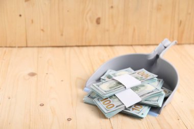 Ahşap arka planda dolar banknotları olan faraş. Metin için boşluk