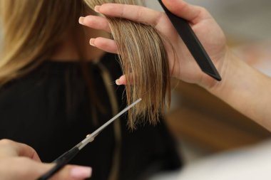 Kuaför kuaförde kadın saçı kesiyor, yakın plan.