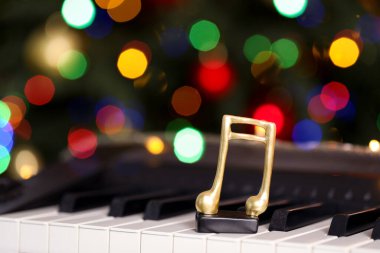 Piyanonun üzerindeki altın nota bulanık Noel ışıklarına karşı, yazı için yer. Bokeh etkisi