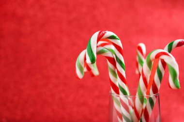 Kırmızı arka planda bir sürü şeker kamışı, metin için yeri olan yakın plan. Noel hediyesi