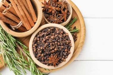 Kâselerdeki farklı baharatlar ve beyaz ahşap masada taze şarap için taze biberiye.