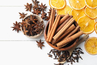 Sıcak şarap baharatları. Tarçın çubukları, anason yıldızları, karanfiller ve kuru portakal dilimleri beyaz ahşap masa, düz yatıyordu.