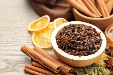 Farklı baharatlar ve portakal dilimleri ahşap masada sıcak şarap için, yakın plan.