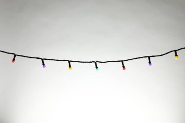 Gri arka planda parlak Noel ışıkları, yakın plan