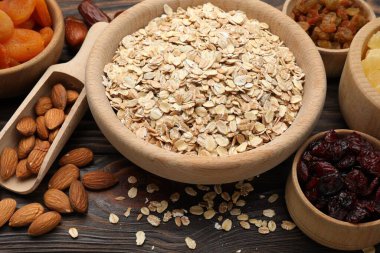 Tahıl yapıyorum. Yulaf gevreği, kurutulmuş meyve ve diğer malzemeler ahşap masada, yakın plan.