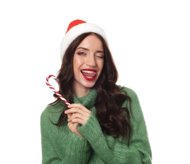 Beyaz arka planda Noel Baba şapkalı ve bastonlu güzel bir kadın. Noel sezonu