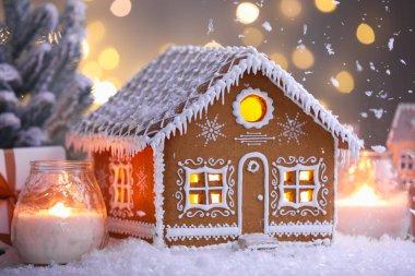 Güzel zencefilli kurabiye evi ve Noel dekoru bulanık ışıklara karşı, yakın plan