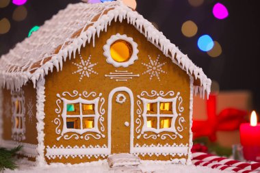 Masanın üzerinde bulanık ışıklara karşı güzel zencefilli kurabiye evi, yakın plan. Noel hediyesi