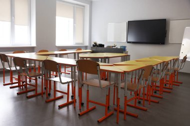 Okulda sarı masalı ve sandalyeli sınıf.