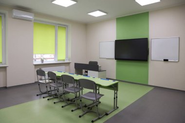 Okulda yeşil masalı, sandalyeli ve televizyonlu sınıf