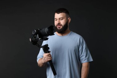 Siyah zemin üzerinde kamera olan titreşimli dengeleyici kullanan kameraman