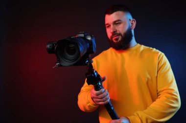 Koyu arkaplana karşı titreşim dengeleyici kullanarak kamerada çekim yapan kameraman, seçici odak noktası