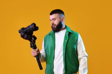 Sarı zemin üzerinde kamera olan titreşimli dengeleyici kullanan kameraman