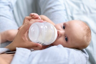 Anne bebeğini biberonla besliyor.