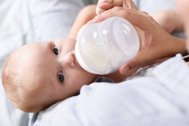 Anne bebeğini biberonla besliyor.