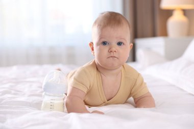 Evde yatağında biberonla beslenen tatlı bir bebek. Metin için boşluk