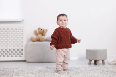 İlk adımlar. Odada duran şirin küçük bebek