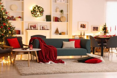 Noel ağacı, kanepe, şömine ve şenlikli dekorlu şık bir oda. İç tasarım