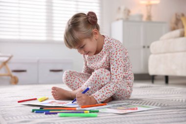 Evinde keçeli kalemle çizen sevimli küçük kız.