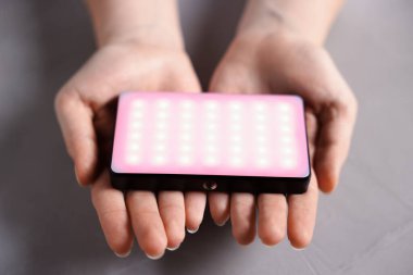 Işıklı arka planda parlayan LED lambalı kadın, yakın plan