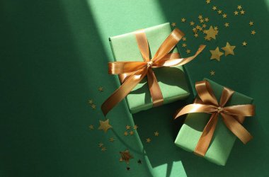 Yeşil arka planda hediyeleri ve dekorasyonu olan güzel bir Noel kompozisyonu. Metin için boşluk