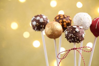 Bej arka planda, bulanık ışıkları olan lezzetli pastalar, yakın plan. Noel hediyesi