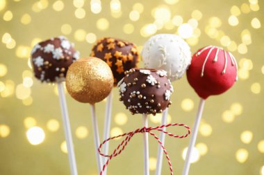 Bej arka planda, bulanık ışıkları olan lezzetli pastalar, yakın plan. Noel hediyesi