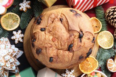 Lezzetli panettone keki, zencefilli kurabiye, baharat, şekerli meyve ve Noel süslemesi, siyah masa, düz uzanma