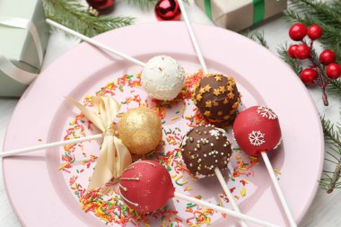 Tatlı kek parçaları ve Noel süsü ile masada, yakın plan.