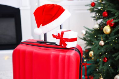 Noel tatili. İçinde Noel Baba şapkası ve hediye kutusu olan bavul, kapalı.