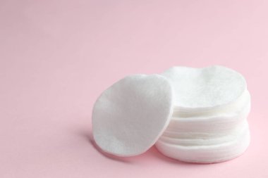 Pembe arka planda bir yığın temiz pamuk pedi, yakın plan. Metin için boşluk