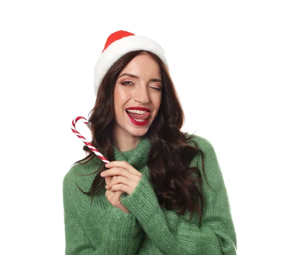 Beyaz arka planda Noel Baba şapkalı ve bastonlu güzel bir kadın. Noel sezonu