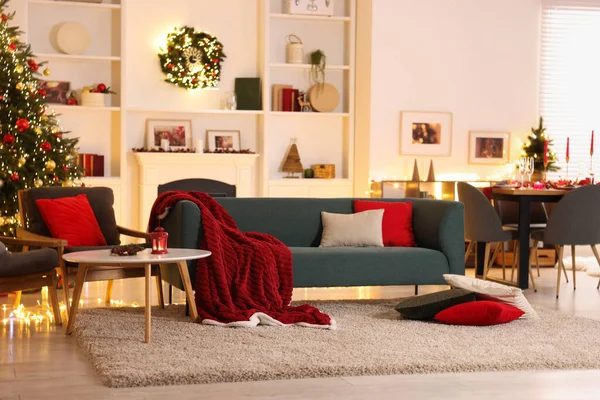 Noel ağacı, kanepe, şömine ve şenlikli dekorlu şık bir oda. İç tasarım
