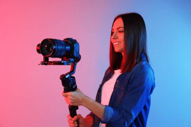 Arkaplanda renk ışıklarıyla titreşim dengeleyici kullanarak kamerada çekim yapan kameraman