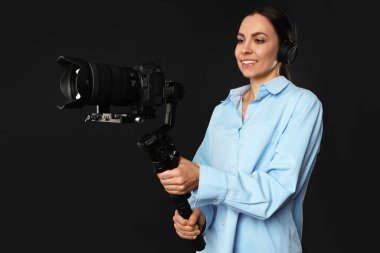 Siyah zemin üzerinde kamera olan titreşimli dengeleyici kullanan kameraman